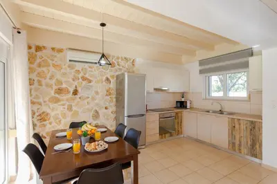 a kitchen and dining room with a table and chairs at Renthub Villas at Kolympia in Kolimbia