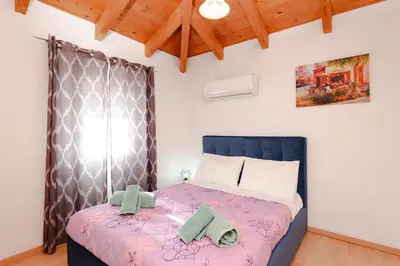 a bedroom with a bed with towels on it at Renthub Villas at Kolympia in Kolimbia