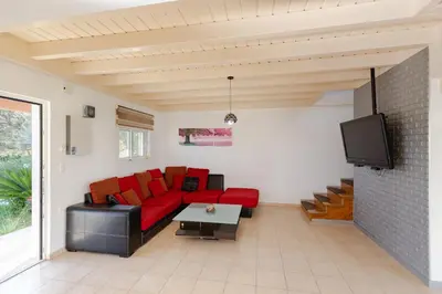 a living room with a red couch and a tv at Renthub Villas at Kolympia in Kolimbia