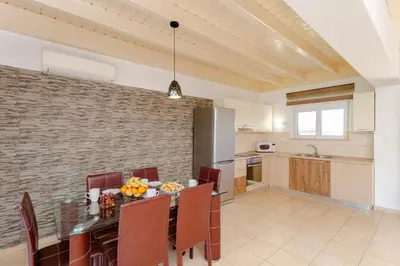 a kitchen and dining room with a table and chairs at Renthub Villas at Kolympia in Kolimbia
