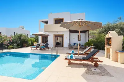 a villa with a swimming pool and a house at Villa Petalouda by Villa Plus in Kalathos