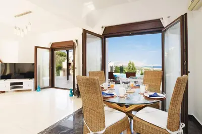 a dining room with a glass table and chairs at Villa Petalouda by Villa Plus in Kalathos