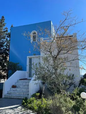 a blue and white house with stairs and a tree at Beachfront Studio Socrates in Gennadi