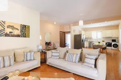 a living room with two white couches and a kitchen at Villa Kalathos by Villa Plus in Kalathos