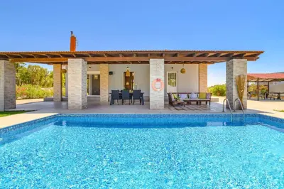 a villa with a swimming pool and a patio at Villa Kalathos by Villa Plus in Kalathos