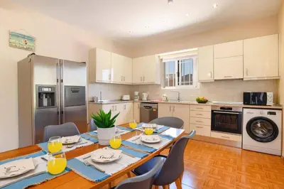 a kitchen with a table and chairs in a kitchen at Villa Kalathos by Villa Plus in Kalathos