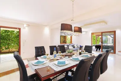 a dining room and living room with a table and chairs at Villa Harmony Rhodes by Villa Plus in Koskinou