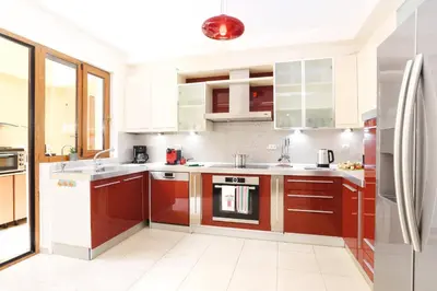 a kitchen with red cabinets and a refrigerator at Villa Harmony Rhodes by Villa Plus in Koskinou