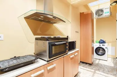 a kitchen with a stove and a microwave at Villa Harmony Rhodes by Villa Plus in Koskinou