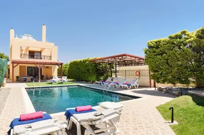 a swimming pool with lounge chairs and a house at Villa Harmony Rhodes by Villa Plus in Koskinou