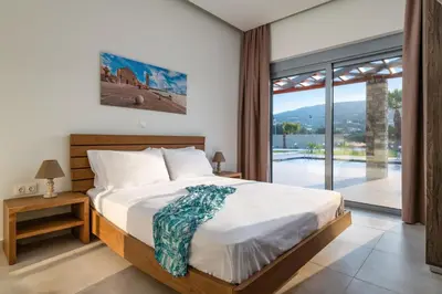 a bedroom with a bed and a large window at Villa Elite Kalathos by Villa Plus in Kalathos