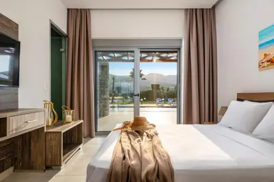 a bedroom with a bed and a large window at Villa Elite Kalathos by Villa Plus in Kalathos