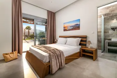 a bedroom with a bed and a large window at Villa Elite Kalathos by Villa Plus in Kalathos