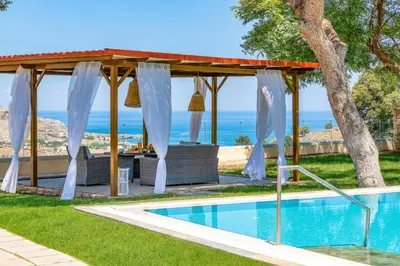 a swimming pool with a gazebo next to a house at Villa St Nicholas by Villa Plus in Pefki Rhodes