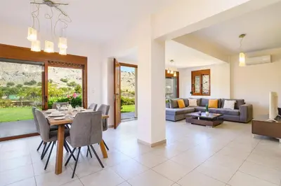 a dining room and living room with a table and chairs at Villa St Nicholas by Villa Plus in Pefki Rhodes