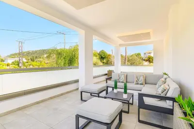 a living room with a couch and chairs and windows at Villa Costa by Villa Plus in Ialyssos