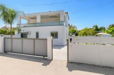 a white house with a gate and a fence at Villa Costa by Villa Plus in Ialyssos