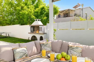 a patio with a couch with a table with fruit on it at Villa Costa by Villa Plus in Ialyssos