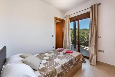 a bedroom with a bed and a large window at Villa Kiotari by Villa Plus in Kiotari