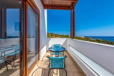 a balcony with two chairs and a view of the ocean at Villa Kiotari by Villa Plus in Kiotari