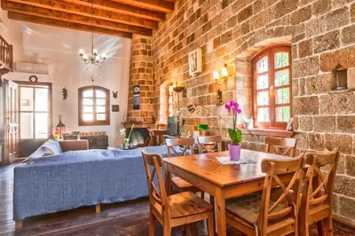 a living room with a wooden table and chairs at VILLA VICTORIA OLD TOWN in Rhodes Town