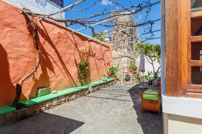 a walkway with green benches next to a building at VILLA VICTORIA OLD TOWN in Rhodes Town