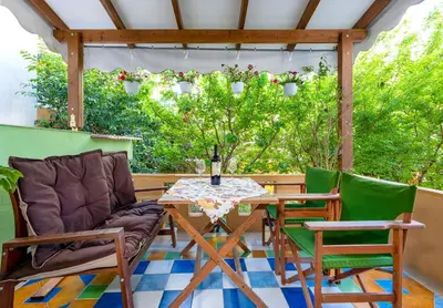 a patio with a table and chairs on a deck at Eddy's Apartment in Rhodes Town