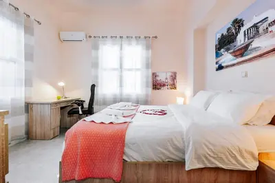 a bedroom with a large bed and a desk at Eddy's Apartment in Rhodes Town