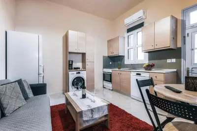 a kitchen and living room with a couch and a table at Eddy's Apartment in Rhodes Town
