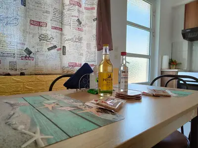 a bottle of alcohol sitting on a wooden table at Hibiscus Green Apartments in Afantou