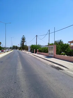 an empty street with a building on the side of the road at Hibiscus Green Apartments in Afantou