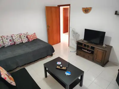 a living room with a couch and a flat screen tv at Hibiscus Green Apartments in Afantou