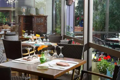 a restaurant with tables and chairs on a patio at Dionysos Hotel in Ixia