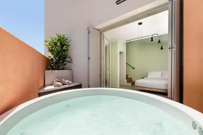 a bath tub in a room with a bedroom at Rhodes Island View in Ixia