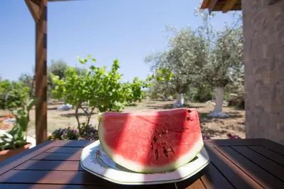 a slice of watermelon on a plate on a table at Serenity Studio Beach Home in Afantou