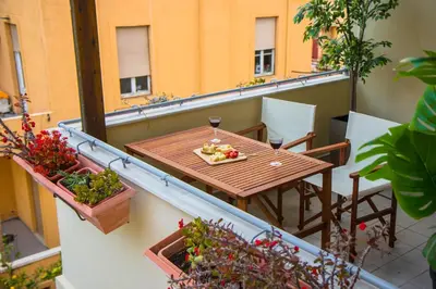 a balcony with a table and two glasses of wine at Niochori Heritage: The Pianist Suite in Rhodes Town