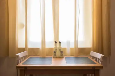 a wooden table with two chairs and a window at Niochori Heritage: The Pianist Suite in Rhodes Town