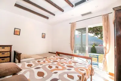 a bedroom with a bed and a large window at Villa Olympos Ladiko in Kalithies