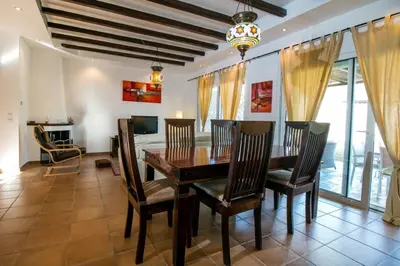 a dining room with a wooden table and chairs at Villa Olympos Ladiko in Kalithies