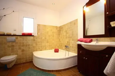 a bathroom with a tub and a sink and a toilet at Villa Olympos Ladiko in Kalithies