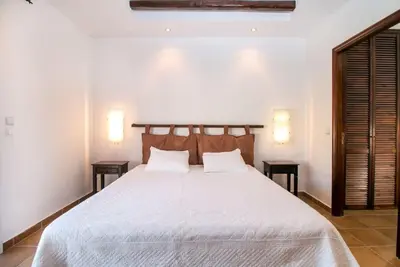 a bedroom with a large white bed with two tables at Villa Olympos Ladiko in Kalithies