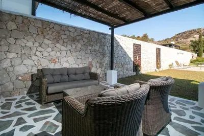 a patio with a couch and chairs and a table at Villa Olympos Ladiko in Kalithies