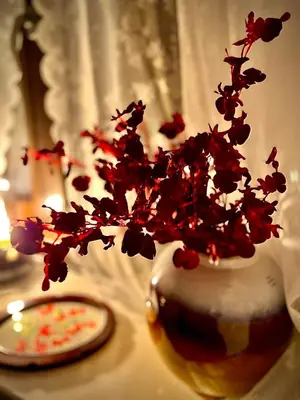 a vase filled with red flowers on a table at Carmen Art Hotel in Rhodes Town