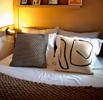 a bed with white pillows and black and white pillows at Carmen Art Hotel in Rhodes Town