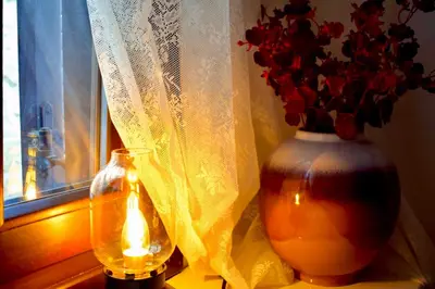 a candle and a vase with flowers in a window at Carmen Art Hotel in Rhodes Town