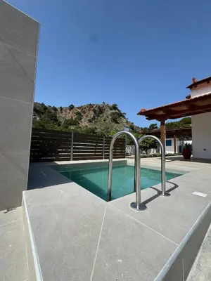 a swimming pool in a house with metal faucets at Aleyna house Lindos area in Líndos