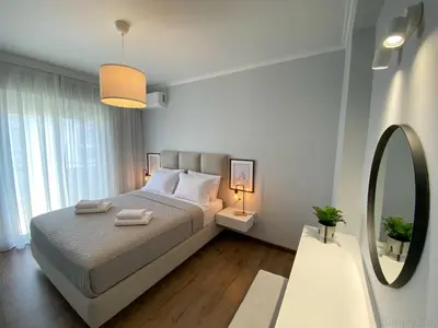 a bedroom with a large bed and a mirror at SimplyCity Homestay Apartment 1 in Kremasti