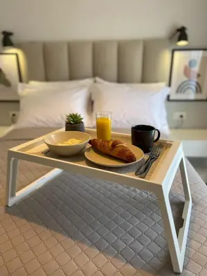 a coffee table with a tray of food on a bed at SimplyCity Homestay Apartment 1 in Kremasti