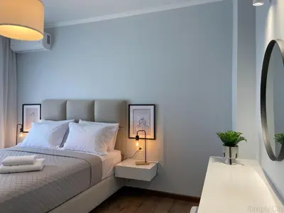 a bedroom with a white bed and a mirror at SimplyCity Homestay Apartment 1 in Kremasti