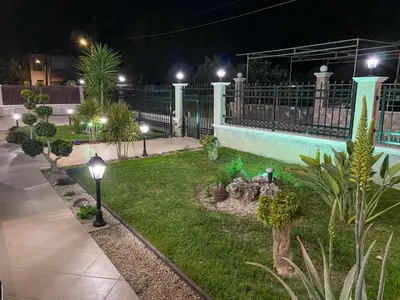 a garden at night with street lights and plants at SimplyCity Homestay Apartment 1 in Kremasti